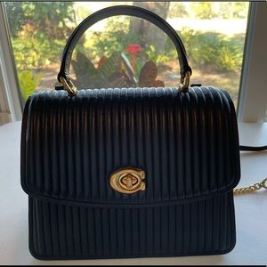 Black leather Coach bag with gold details and purple velvet interior